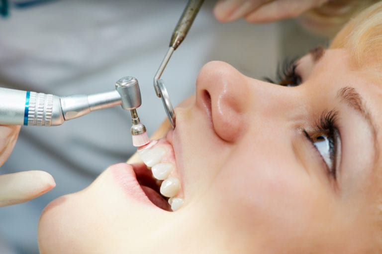 young woman receiving dental cleaning