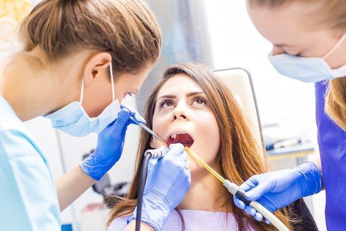 Beautiful woman patient having dental treatment at dentist's office.