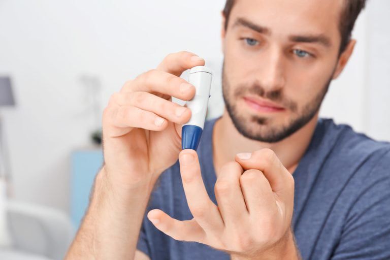 Man taking blood sample with lancet pen